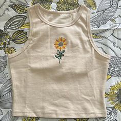 Crop top with sunflower embroidery.  Made of Cotton and Spandex. Tank Top Embroidery Ideas, Casual Embroidered Fitted Tank Top, Trendy Sleeveless Tops With Floral Embroidery, Embroidered Fitted Tank Top For Spring, Fitted Embroidered Tank Top For Spring, Summer Casual Tank Top With Floral Embroidery, Fitted Casual Tank Top With Floral Embroidery, Casual Fitted Tank Top With Floral Embroidery, Fitted Casual Crop Top With Floral Embroidery