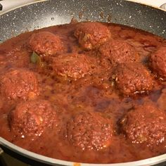 meatballs and sauce cooking in a pan on the stove