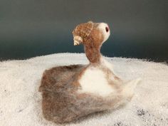 a stuffed animal sitting on top of snow covered ground with it's head in the air