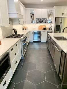 a kitchen with white cabinets and gray flooring