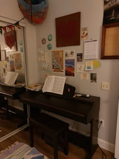 a piano sitting on top of a hard wood floor next to a wall covered in pictures