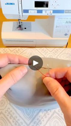 two hands are working on the sewing machine