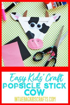 a cow made out of paper and scissors on a table with text overlay that reads easy kids'craft popsicle stick cow