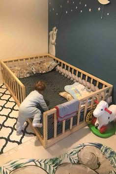 a little boy that is laying down in a crib