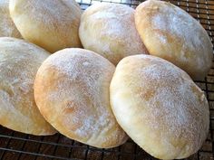 six sugar - coated doughnuts cooling on a wire rack, ready to be baked