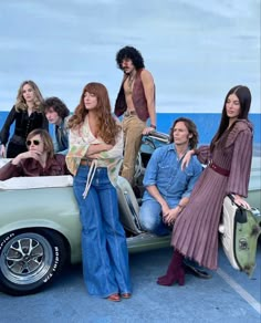 several people are sitting on the back of an old car and posing for a photo