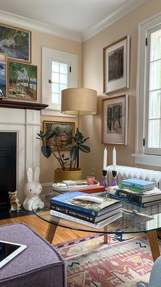 a living room filled with lots of furniture and pictures on the wall above it's fireplace