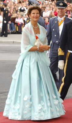 the queen and prince are walking down the red carpet