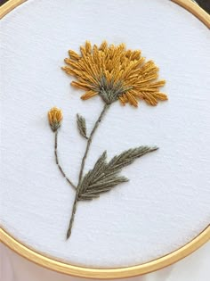 a close up of a embroidery on a piece of cloth with flowers in the middle