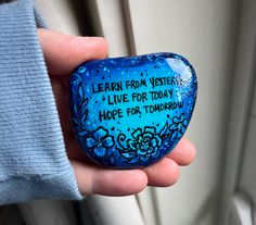 a hand holding a rock that says learn from mystery live for today hope for tomorrow