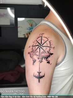 a man's arm with a compass tattoo on it, and the world map