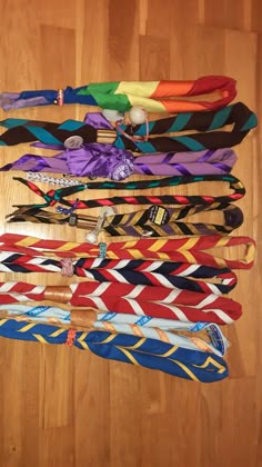 a bunch of ties laid out on a wooden floor with one tied to the side