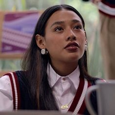 a woman with long hair wearing a white shirt and red suspenders is looking off to the side