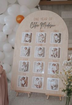 a baby's first year photo display with balloons and flowers in the back ground