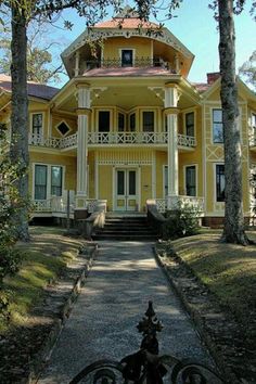 a bike parked in front of a large yellow house with porches and balconies