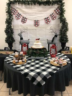 a table topped with cakes and cupcakes on top of a checkered table cloth