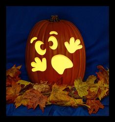 a pumpkin carved to look like a face with eyes and hands, surrounded by leaves