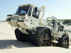 a large white truck parked on top of a sandy beach