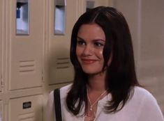 a woman standing in front of lockers smiling at the camera