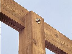 a close up of a wooden cross with the sky in the backgroung