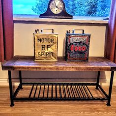 an old table with two bags on it and a clock in the window sill