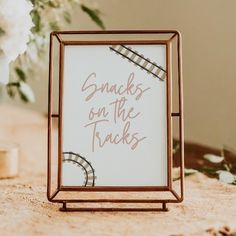 a sign that says snacks on the tracks in front of some flowers and other decorations