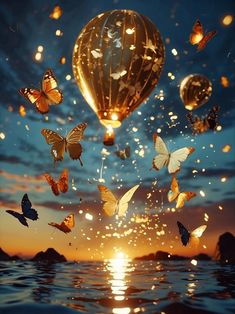 there are many butterflies flying in the air over water at sunset or sunrise, and one balloon is floating above the water