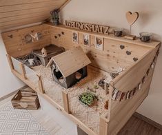 a small wooden house with lots of sand in the floor and some pictures on the wall