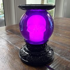 a purple skull light sitting on top of a wooden table