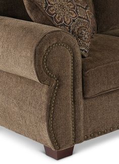 a brown couch with pillows on it and a pillow in the back corner, sitting against a white background