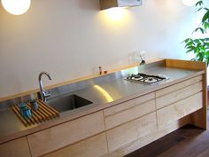 a modern kitchen with stainless steel counter tops and wooden cabinets is pictured in this image