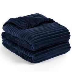 three blue blankets stacked on top of each other in front of a white background,