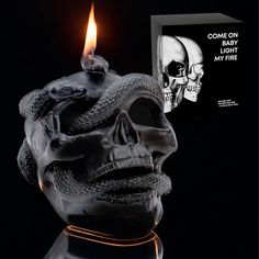 a candle with a skull on it next to a box that says come on light my fire