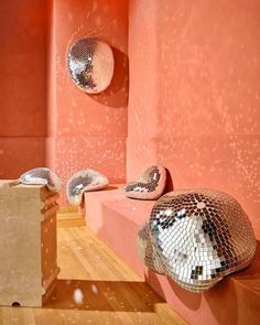 two disco balls sitting on top of a wooden floor next to a mirror ball sculpture