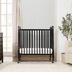 a baby crib in a living room next to a window