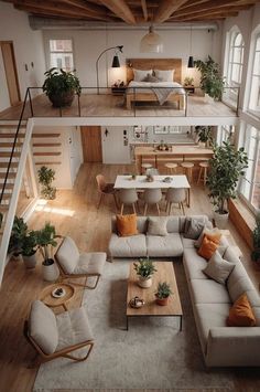 an overhead view of a living room and dining area with couches, chairs, coffee table and stairs