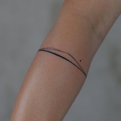 a woman's arm with a small tattoo on it