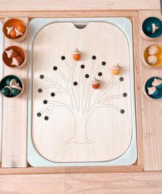 a wooden tray with several bowls and cups on it, including an apple tree cutout