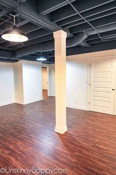 an empty room with wood flooring and white walls, in the middle of a building