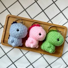 three crocheted keychains in the shape of elephants on a wooden tray