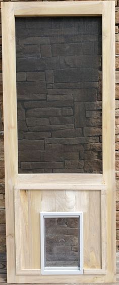 a wooden frame with a window on top of it and a brick wall in the background