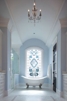 a bath room with a tub and a chandelier