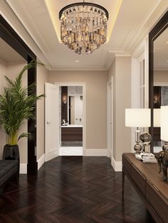 a living room filled with furniture and a chandelier hanging from the ceiling over a wooden floor