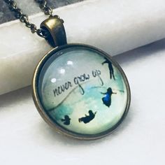 a glass pendant with the words never give up on it and birds flying in the sky