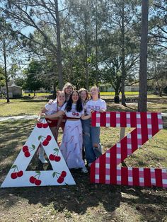 three girls posing in front of the letter z with cherries on it