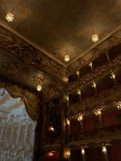 an ornately decorated auditorium with chandeliers and curtains