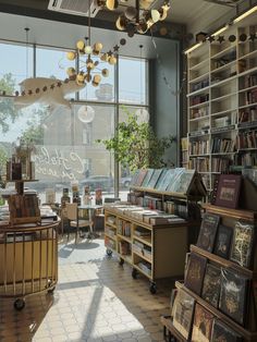 a library filled with lots of books next to a large window covered in glass windows