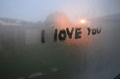 the word i love you written on a frosted glass window with light behind it