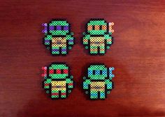 four perler beads sitting on top of a wooden table