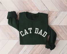 "Calling all cat dads! Embrace your love and pride for your feline companion with our cozy and stylish Cat Dad Sweatshirt. This sweatshirt is the purr-fect way to showcase your affection and bond with your beloved fur baby. Crafted with care, our sweatshirt is made from premium-quality, soft, and comfortable fabric to keep you cozy and warm all day long. The eye-catching \"Cat Dad\" design is professionally printed, letting the world know about your special connection with your cat. Whether you' Cat Mom Sweatshirt, Cat Dad Gifts, Black Cat Lover, University Style, Cadeau Parents, Cat Parenting, Love And Pride, Cat Sweatshirt, Cozy Gift